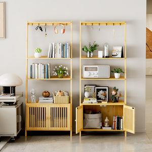 A stylish room features two wooden bookshelves filled with books, plants, decor, and a radio, alongside a sleek lamp and cabinet.