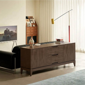 A stylish living room featuring a modern brown cabinet, a black sofa, a colorful vase, and a sleek floor lamp beside sheer curtains.