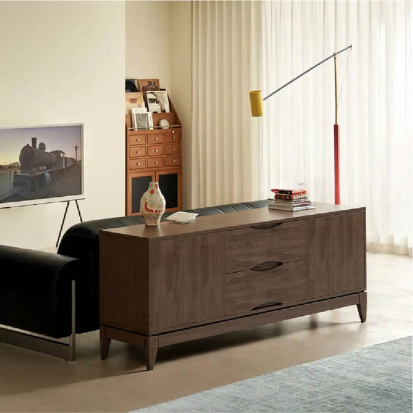 A stylish living room featuring a modern brown cabinet, a black sofa, a colorful vase, and a sleek floor lamp beside sheer curtains.