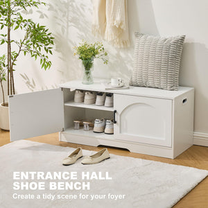 A white shoe bench in a foyer, featuring multiple shoes, a decorative vase with flowers, a cozy pillow, and a cup on top.