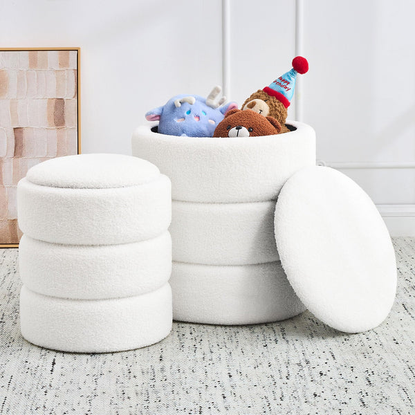 A stack of three plush white storage ottomans, one opened with colorful stuffed animals peeking out, on a textured rug.