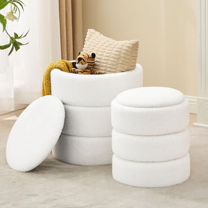 Two stylish, white, plush fabric storage stools with a whimsical plush tiger toy and a cozy yellow throw on one.