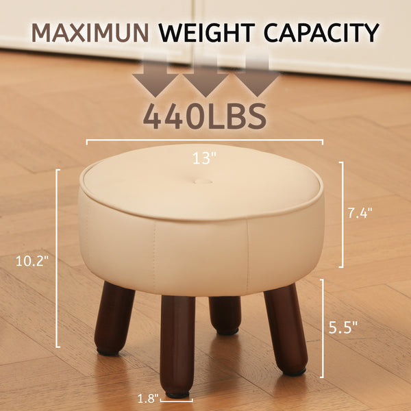 A cream-colored ottoman with dimensions and a maximum weight capacity of 440 lbs, resting on four dark wooden legs on a wood floor.
