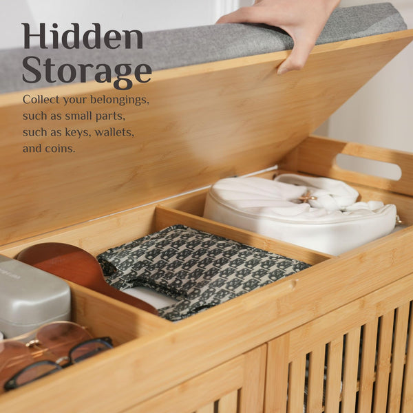 A hand lifting the lid of a bamboo storage box reveals compartments filled with small belongings like sunglasses, a wallet, and a pouch.