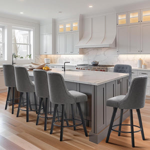 Modern kitchen with gray upholstered bar stools at a marble-topped island, sleek cabinetry, and large windows for natural light.