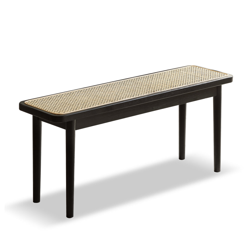 A stylish wooden bench with a plush, white seat is illuminated by sunlight, set against framed botanical art and a leafy plant backdrop.